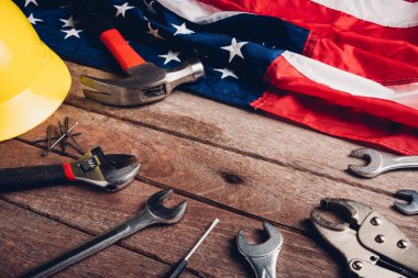 ABD İşçi Bayramı konsepti, ahşap masa üzerinde Amerikan bayrağı olan çeşitli İngiliz anahtarı. Eylül 'ün ilk pazartesi günü, işçi hareketinin kurulması ve Amerikan işçilerinin sosyal hizmetlerine adanması.