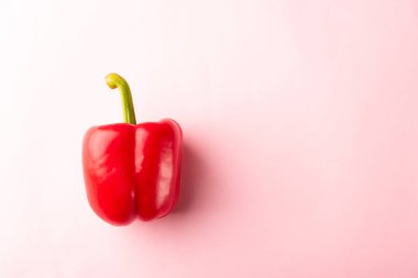 Pembe pastel arka planda çiğ kırmızı çan biberlerinin, taze organik sebzelerin, sağlıklı yaşam tarzı diyet gıda konseptinin üzerine yakın plan.