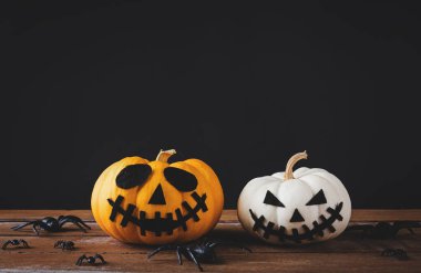 Cadılar Bayramı parti konsepti hayalet balkabakları baş fener korkutucu gülümseme ve tahta masa ve siyah arka planda örümcek, stüdyo çekimi izole edilmiş, tatil dekorasyonu