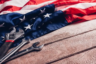 ABD İşçi Bayramı konsepti, ahşap masa üzerinde Amerikan bayrağı olan çeşitli İngiliz anahtarı. Eylül 'ün ilk pazartesi günü, işçi hareketinin kurulması ve Amerikan işçilerinin sosyal hizmetlerine adanması.