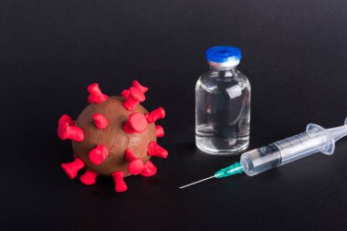 Kapalı plastisin hastalıkları hücreleri virüs aşısı ve Coronavirus salgını ve koronavirüs gribi şırıngası, kara arka planda izole edilmiş stüdyo çekimi, salgın COVID-19 tıbbi sağlık