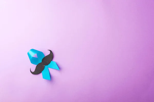 黑色胡子纸和浅蓝色带子 工作室拍摄孤立紫色背景 前列腺癌意识月 父亲节 最小的11月胡子概念 — 图库照片