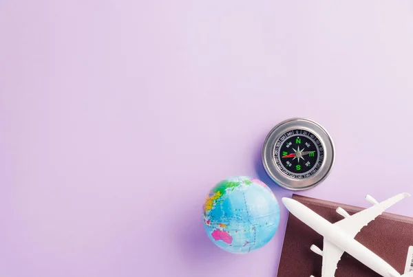 世界観光デー 最小限のおもちゃのモデル飛行機 コンパスと地球 スタジオは テキスト 休日の旅行のコンセプトのためのコピースペースと紫色の背景に隔離されたショット — ストック写真