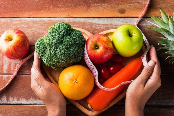 世界粮食日 各种新鲜有机水果蔬菜在心盘和女人手中拿着盘子 工作室拍摄木桌 健康素食理念 — 图库照片