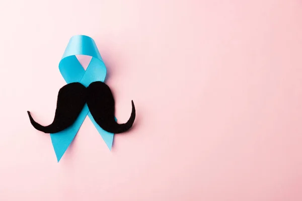 黑色胡子纸和浅蓝色带子 工作室拍摄孤立粉红背景 前列腺癌意识月 父亲节 最小的11月胡子概念 — 图库照片