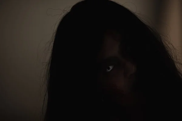 血淋淋的女僵尸亚洲女人血迹斑斑的脸和眼睛 在黑暗的房子里令人毛骨悚然的恐惧 蒙面的头发 万圣节的概念 — 图库照片