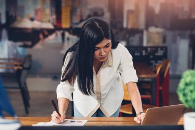 Hayat tarzı serbest çalışan bir kadın ve dizüstü bilgisayar. Kahve dükkanında grafiksel kar tablosunu inceledi.