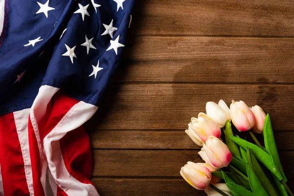 America United States flag and tulip flower, memorial remembrance and thank you of hero, studio shot with copy space on wooden background, USA holiday Veterans or Independence day concept