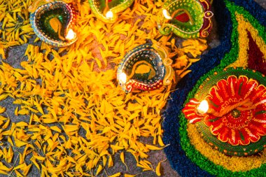 Çamuru kapat Diya 'ya ateş yak ya da arka planda çiçek olan gaz lambası, Hinduizm Rangoli Dekorasyonu, Mutlu bayramlar Deepavali, ya da Diwali Hint festivali konsepti