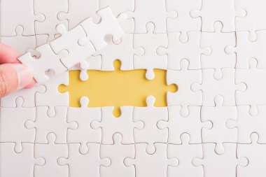 Top view düz konum son parça beyaz kağıt yapboz oyunu çözülmesi için yerleştirilen son parçalar tam görev, stüdyo çekimi sarı arkaplan, quiz hesaplama konsepti