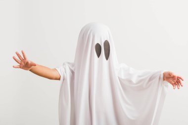 Komik cadılar bayramı çocuğu kavramı, beyaz kostümlü şirin çocuk cadılar bayramı hayaleti korkunç, stüdyo resmi beyaz arka planda izole edilmiş.