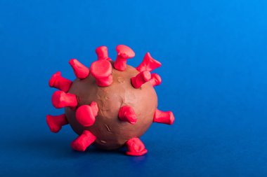 Koronavirüs salgını ve koronavirüs gribi virüsü kapatılan plasticine hastalığı hücreleri, mavi arka planda izole edilmiş stüdyo çekimi, salgın COVID-19 tıbbi sağlık riski konsepti
