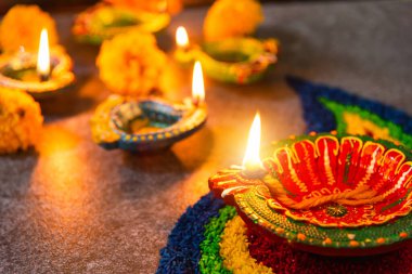 Çamuru kapat Diya 'ya ateş yak ya da arka planda çiçek olan gaz lambası, Hinduizm Rangoli Dekorasyonu, Mutlu bayramlar Deepavali, ya da Diwali Hint festivali konsepti