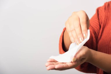 Asyalı kadının elini kapat. Islak mendil kullanıyor. Ellerini temizliyor. Stüdyo resmi beyaz arka planda izole edilmiş.