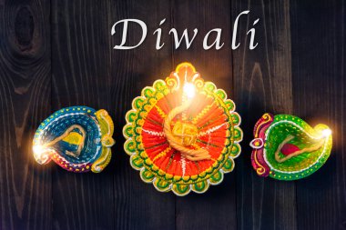 Üst tepedeki kil Diya ya da petrol lambası için ateş yakıyor, stüdyo siyah ahşap arka planda çekiliyor, Hinduizm Rangoli Dekorasyonu, Mutlu bayramlar Deepavali ya da Diwali festivali konsepti