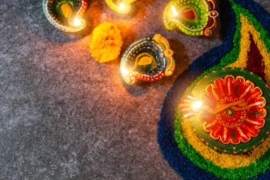 Çamuru kapat Diya 'ya ateş yak ya da arka planda çiçek olan gaz lambası, Hinduizm Rangoli Dekorasyonu, Mutlu bayramlar Deepavali, ya da Diwali Hint festivali konsepti