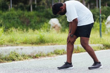 Kapatın Asyalı genç spor koşucusu, saat takın, el ele tutuşun, el ele tutuşun, koşarken diz çökün, sağlık parkında koşun, spor konseptinden dolayı sağlıklı egzersiz sakatlığı.