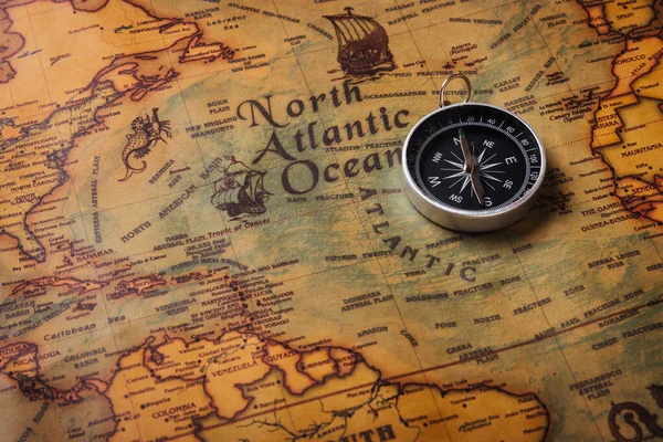 Old compass discovery on vintage paper antique world map background, Retro style cartography travel geography navigation, Pirate navigate the geography