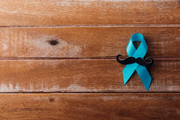 November Blue, Light blue ribbon with a man mustache on wooden background, Men health awareness, Prostate Cancer Awareness