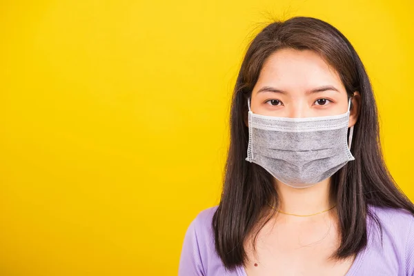 閉じるアジアの若いですティーン女性身に着けています顔マスク保護に対するコロナウイルス Covid 19ウイルスやフィルターダストPm2 5と大気汚染彼女はカメラスタジオショット隔離された黄色の背景 — ストック写真