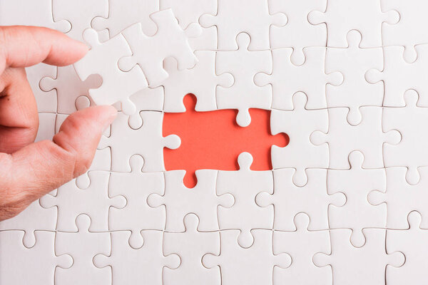 Вид сверху плоский лежал последний кусок белой бумажной головоломки, последние кусочки, поставленные на место для решения задачи, студийный снимок на розовом фоне, quiz calcuze concept