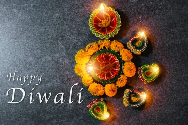 关闭的粘土点燃了已经在Diya上燃起的篝火 或者用鲜花点燃了油灯 在混凝土背景上拍摄了工作室 装饰了印度教的兰戈里 快乐地庆祝了Deepavali或Diwali印第安人节的概念 — 图库照片