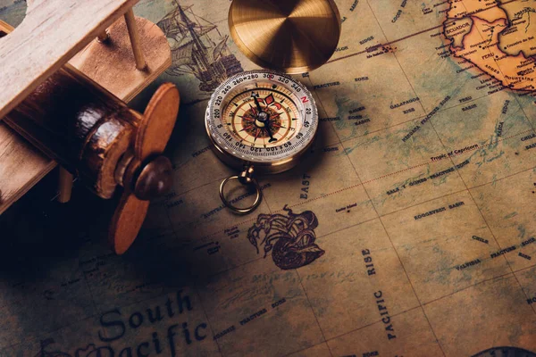 古いコンパス発見とヴィンテージ紙アンティーク世界地図の背景に木製の飛行機 レトロスタイルの地図旅行地理ナビゲーション — ストック写真
