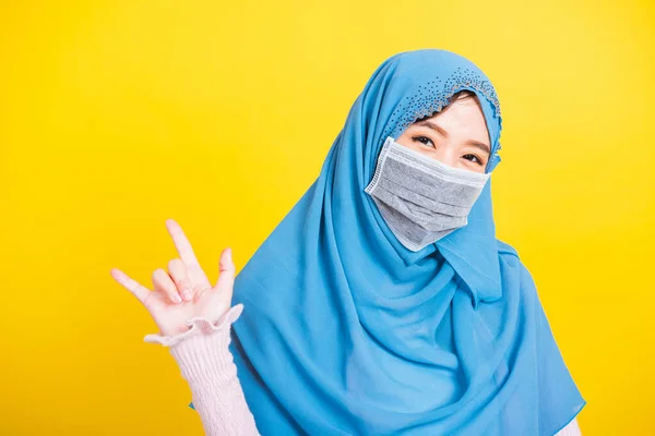 アジア系イスラム教徒アラブ人 幸せな美しい若い女性の肖像イスラム教の宗教的な摩耗ベールヒジャーブと顔のマスクは 隔離された黄色のサインを手指 Love You を示しています — ストック写真
