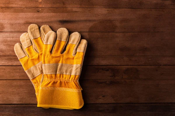Nahaufnahme Von Gelben Schutzhandschuhen Auf Holzgrund — Stockfoto