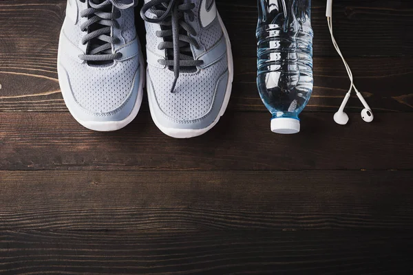 Draufsicht Auf Paar Sportschuhe Kopfhörer Und Wasserflasche Auf Schwarzem Holztischhintergrund — Stockfoto