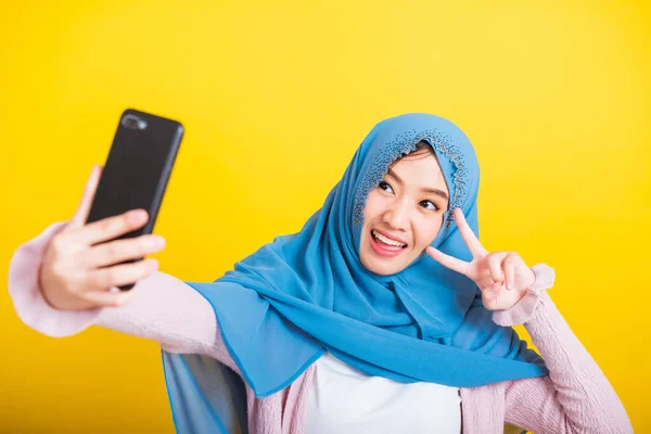 アジア系ムスリムアラブ人 幸せな美しい若い女性の肖像 イスラームという宗教的な摩耗ベールヒジャーブ面白い笑顔彼女はスマートフォンで自撮り 黄色の背景に隔離されたスタジオショット — ストック写真