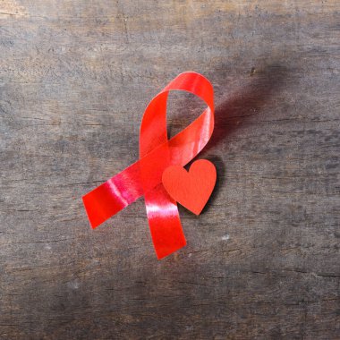 Kırmızı Kurdele HIV, AIDS ve kırmızı kalbi ahşap arka planda ve kullanım için kopyalama alanında destekliyor
