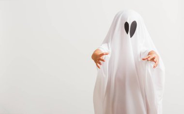 Komik cadılar bayramı çocuğu kavramı, beyaz kostümlü şirin çocuk cadılar bayramı hayaleti korkunç, stüdyo resmi beyaz arka planda izole edilmiş.