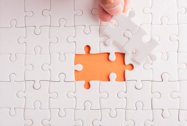 Top view düz konum son parça beyaz kağıt yapboz oyunu çözülmesi için yerleştirilen son parçalar tam görev, turuncu arka plan üzerine stüdyo çekimi, sınav hesaplama konsepti