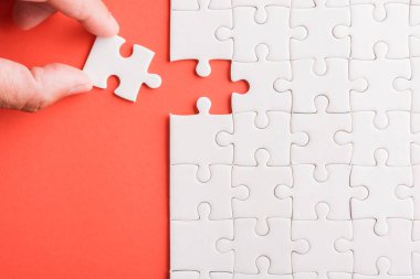 Üst görünüm düz konum son parça beyaz kağıt yapboz oyunu çözülmesi için yerleştirilen son parçalar tam görev, pembe arka plan üzerine stüdyo çekimi, quiz hesaplama konsepti