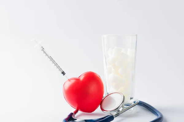 一杯白糖立方体甜食配料和医生听诊器 工作室拍摄了背景为白色 健康高的血液风险糖尿病和卡路里摄入概念和不健康的饮料 — 图库照片