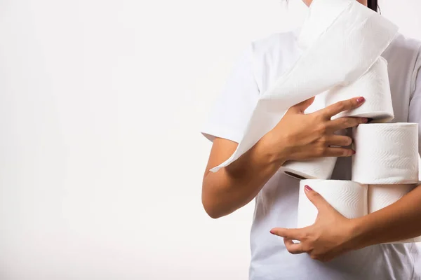 衣冠不整的亚洲女青年在商店里储存卫生纸 以应对家庭恐慌 防止感染考拉韦病毒 女性抱着许多卷起的卫生纸放在胸前 工作室被白色背景隔离 — 图库照片