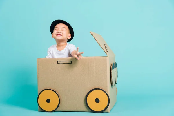 快乐的亚洲孩子们笑着驾驶着纸板箱创意的游戏车 暑假旅行的理念 工作室在蓝色的背景上拍摄带有复制空间的文字 — 图库照片