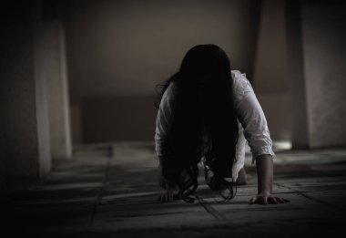 Kanlı dişi zombi. Kanlı Asyalı kadın hayalet. Karanlık evdeki korkunç korku tüyler ürpertici sürünme yavaş yavaş yayılıyor. Saç kaplaması kameraya bakıyor, Cadılar Bayramı festivali konsepti.