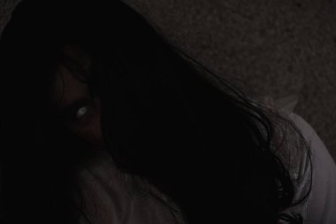 Kanlı dişi zombi. Kanlı Asyalı kadın hayalet. Karanlık bir evde oturması korkunç bir korku. Yüzü örten saç, Cadılar Bayramı festivali konsepti