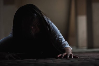 Kanlı dişi zombi. Kanlı Asyalı kadın hayalet. Karanlık evdeki korkunç korku tüyler ürpertici sürünme yavaş yavaş yayılıyor. Saç kaplaması kameraya bakıyor, Cadılar Bayramı festivali konsepti.