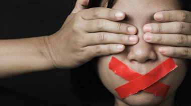Asyalı bir kadın siyah arka planda kırmızı bantla gözlerini bağlıyor. Konuşma özgürlüğü sansürü ve konuşmayı durdurmak, Uluslararası İnsan Hakları Günü