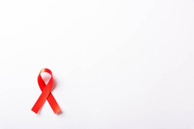 Kırmızı kurdele sembolü HIV, AIDS kanseri gölgeli farkındalık, beyaz arka planda izole edilmiş stüdyo çekimi, sağlık sigortası konsepti, Dünya AIDS Günü