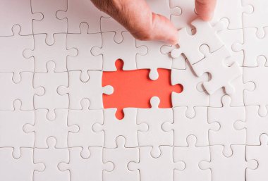 Üst görünüm düz konum son parça beyaz kağıt yapboz oyunu çözülmesi için yerleştirilen son parçalar tam görev, pembe arka plan üzerine stüdyo çekimi, quiz hesaplama konsepti