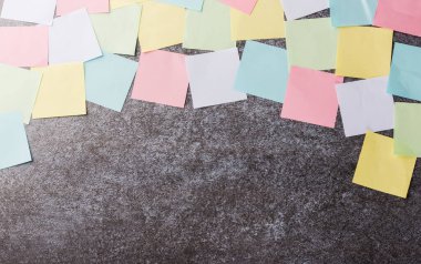 Beton duvar arkaplanı üzerine çok sayıda boş renkli kağıt yapıştırma listesi, iş anımsatıcı bellek post-it notları bugün çalışma kavramı