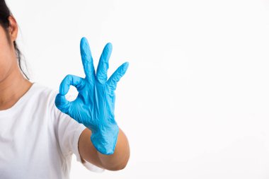 Doktor için mavi kauçuk eldiven takan bir kadın. Tamam işareti olan bir doktor. Stüdyo resmi, beyaz arka planda izole edilmiş.