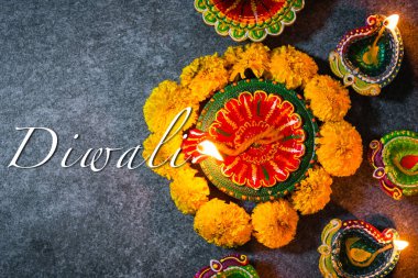 Çamuru kapatın Diya 'yı ya da gaz lambasını çiçeklerle aydınlatın, stüdyonun arka planı beton, Hinduizm Rangoli Dekorasyonu, Deepavali ya da Diwali Hint festivali konseptini kutlayın.