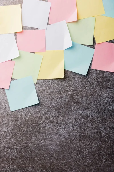Beton duvar arkaplanı üzerine çok sayıda boş renkli kağıt yapıştırma listesi, iş anımsatıcı bellek post-it notları bugün çalışma kavramı