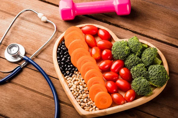 心板木 胡萝卜 西兰花 西红柿 医生听诊器和木制桌子上的运动哑铃 健康的生活方式饮食观念等新鲜有机水果和蔬菜概览 — 图库照片