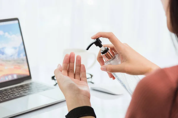 自宅から仕事 バックアジアの若いビジネス女性のビデオ会議のオンラインフロントノートパソコン上で衛生アルコールジェルポンプ検疫疾患コロナウイルスやCovid 19で手を掃除 — ストック写真